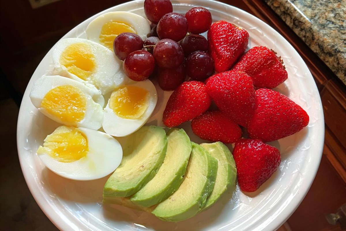 A realistic high-protein breakfast plate with eggs, Greek yogurt, berries and whole grain toast