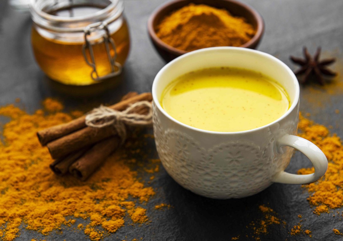 A mug of warm turmeric drink on a kitchen counter in the early morning