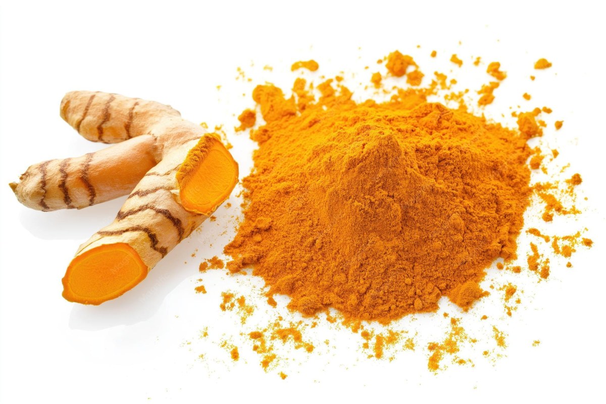 Fresh turmeric roots and turmeric powder on a table