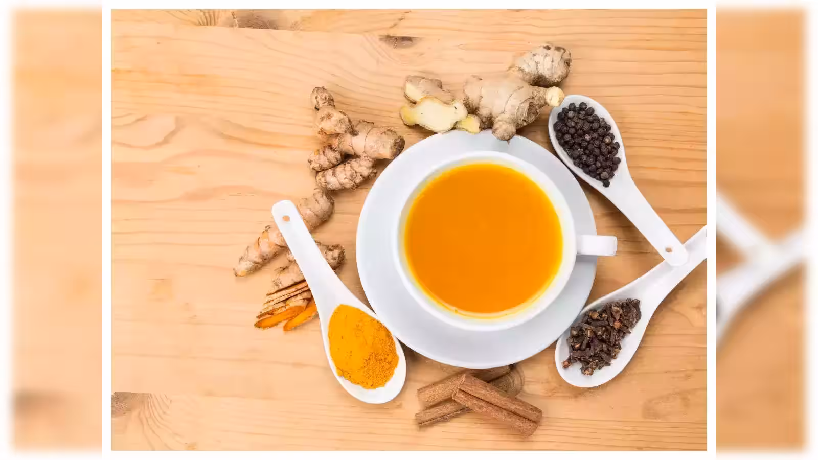 A cozy mug of homemade turmeric tea with fresh turmeric root and spices on a wooden counter